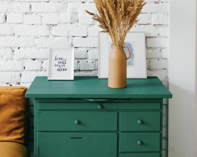 green chest of drawers with decorations on topp